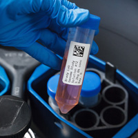 A lab vial labeled with information and a QR code.