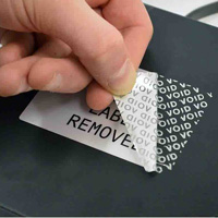 A person peeling a tamper-evident label. It's leaving a residue behind that says 'VOID.'