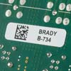 A label on a circuit board with a 2D barcode and text.