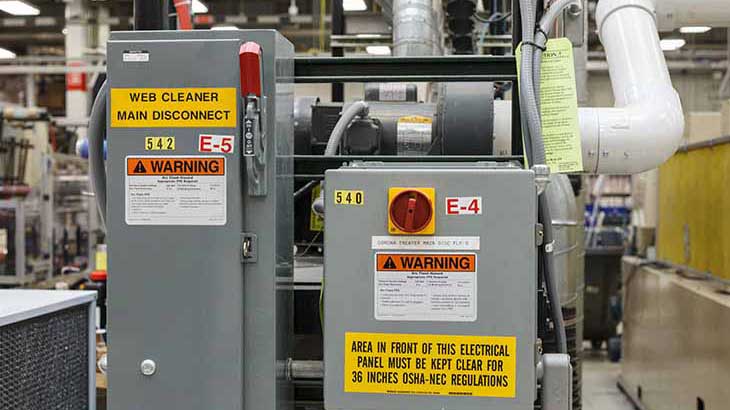 An arc flash and other identification labels on an electrical panel in an industrial environment.