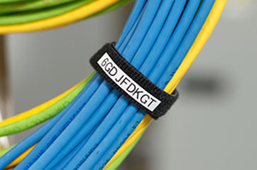 A bundle of wires is organized using a labeled wrap.