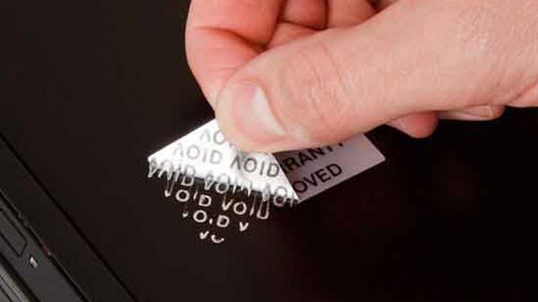 A person removing a tamper evident label. It's leaving a residue that says "Void".