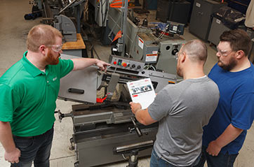 Workers in a manufacturing area reviewing procedures