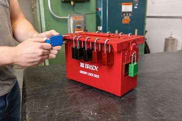 A worker applies an asset tag to a laptop.