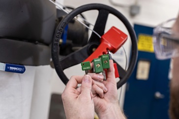 A worker applies an asset tag to a laptop.