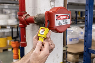 A worker applies an asset tag to a laptop.