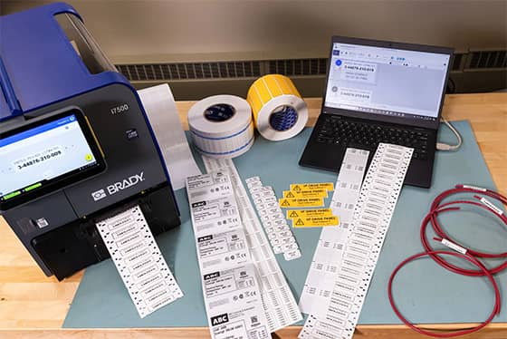 A worker applies an asset tag to a laptop.
