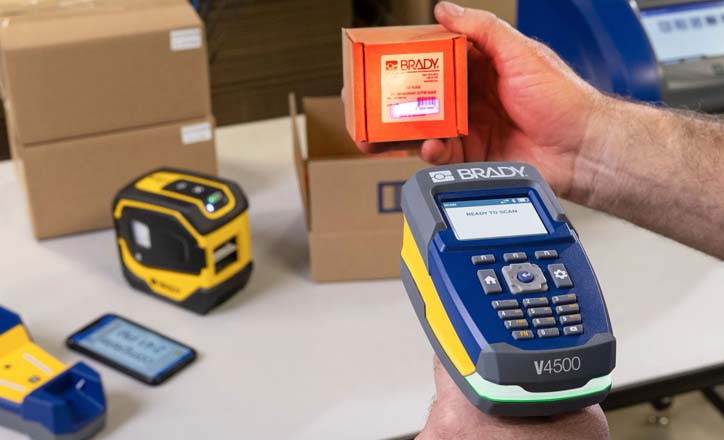 An individual operates a V4500 scanner to read a Brady barcode label on a package.