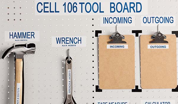 Backdrop of a handyman bench with a wrench, hammer, tape measure, calculator, and two clip boards hanging.