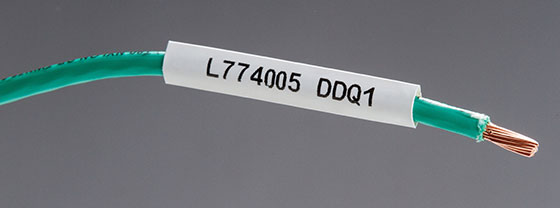 Closeup of a green wire with label, the end is exposed