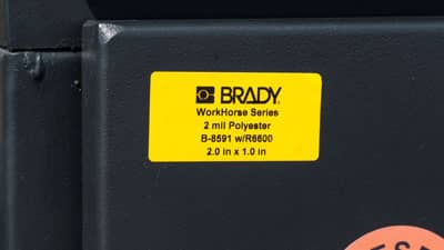 A Brady all-weather polyester label applied to an outdoor service box.