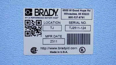 A metallized glossy rating plate label applied to a textured surface.