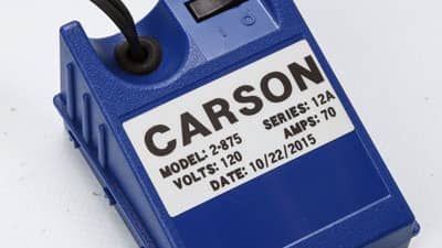 A Brady metallized matte-finish label on an electrical device identifying its voltage and amperage.