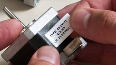 A Brady ultra aggressive adhesive matte finish label being applied to an industrial toggle switch.