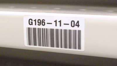 A Brady ultra aggressive adhesive barcode label applied securely to the edge of a shelf to help identify its content.