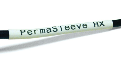 A black wire with a white heat shrink PermaSleeve label applied to it.