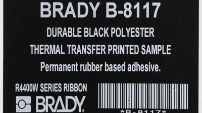 A black identification label with white printing, including a barcode.