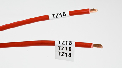 Two red wires labeled with white repositionable wrap around labels.