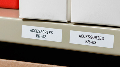 A metal rack has labels on the end to indicate where document binders go.
