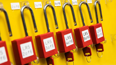 A panel contains lockout tagout devices neatly labeled in a row.