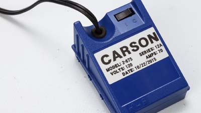 A Brady metallized matte-finish label on an electrical device identifying its voltage and amperage.