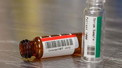 Two vials with a red and green colored polyester labels.