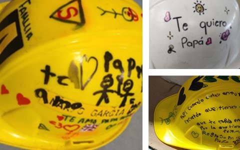 Employees' hardhats with handwritten notes and drawings from their families – reminding them to stay safe.