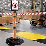 A Brady EasyExtend post with its retractable tape barriers extended to corden off an area of a facility.